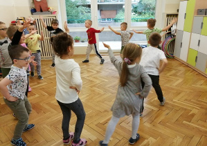 dzieci tańczą w kole do muzyki